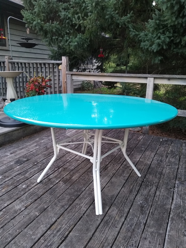 A real powder-coated patio table with a bright turquoise top and white metal base